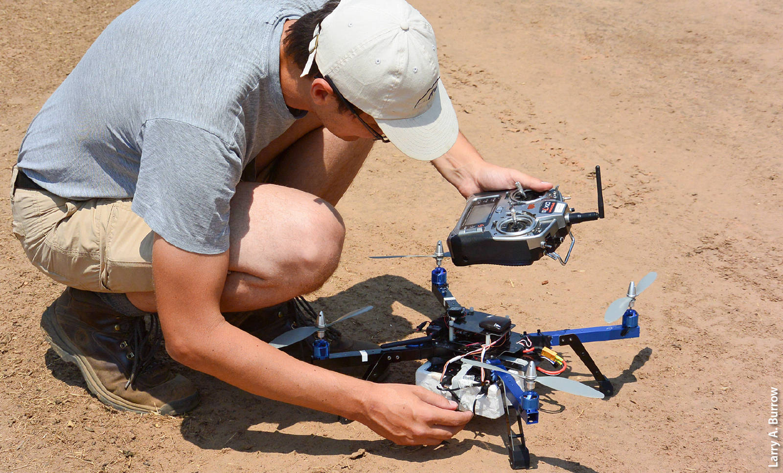 Andreas Anderson, an instructor with the Center for Information Technology Research in the Interest of Society at UC Merced, checks the control systems for a drone-mounted multispectral camera before a research flight in Merced County for a study on water stress in almond trees.