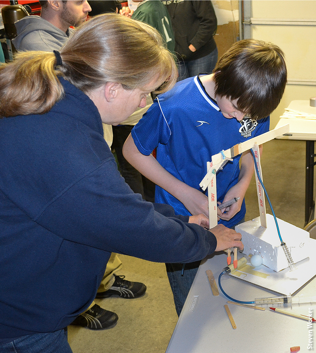 In the design and build participation structure, volunteer educators presented youth with a design challenge and asked them to design and build a device, such as the arm/gripper shown here, to solve the problem. Educators used a variety of teaching techniques for design and build, including targeted questions and offering specific design suggestions.