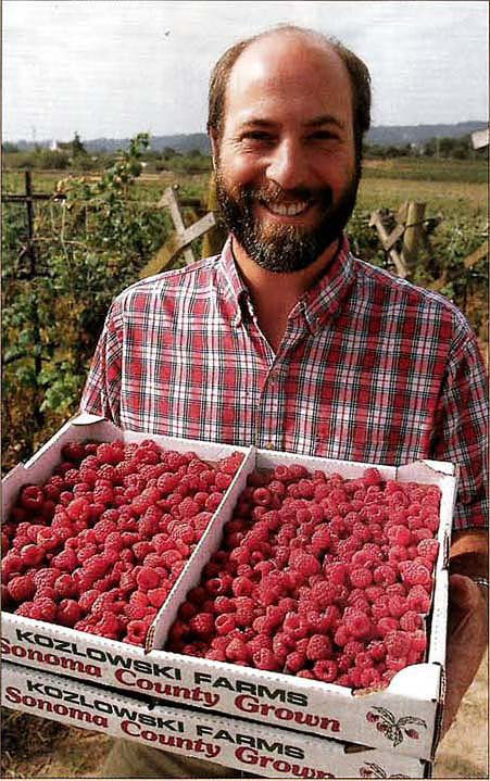Farm Advisor Vossen holds tray of raspberries from the Kozlowski farm.