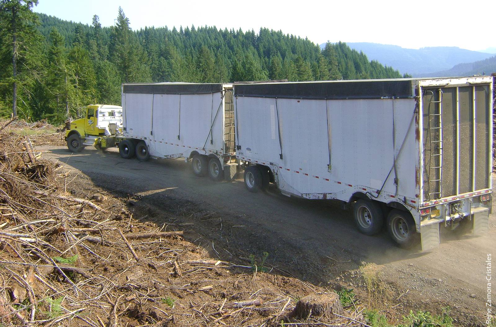 A double-trailer configuration traveling on a forest road near Roseburg, Oregon. In Washington and Oregon, double trailers can be more cost effective than single trailers for transporting forest biomass, but they are not competitive in California due to restrictions on load weight and trailer length.